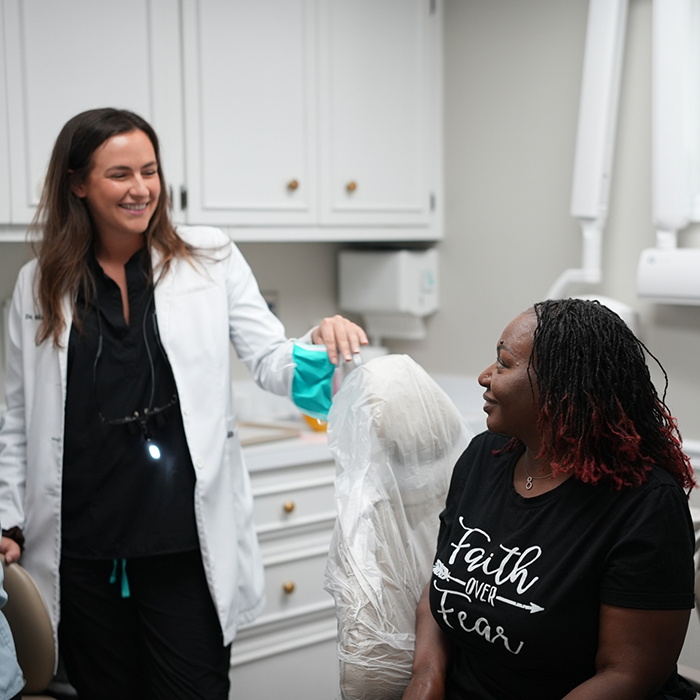 Dentist smiling at a woman in the dental chair