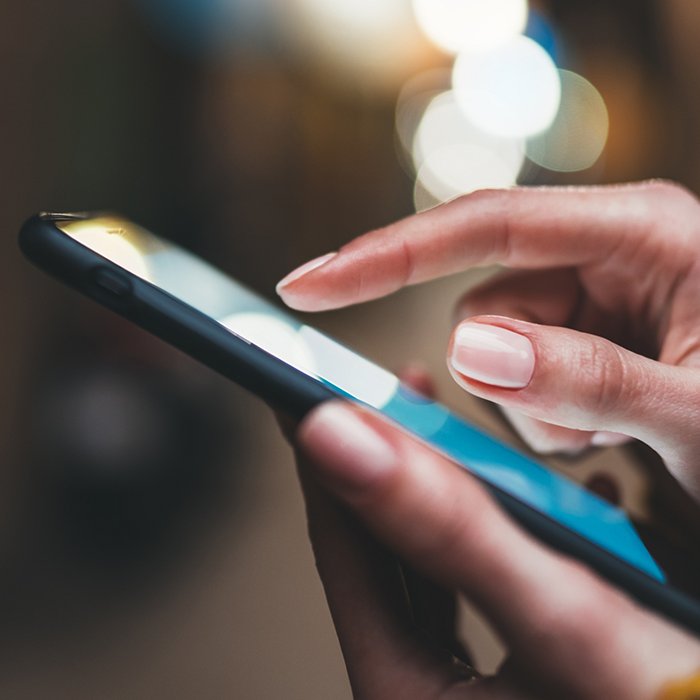 Close up side view of a person scrolling on their phone