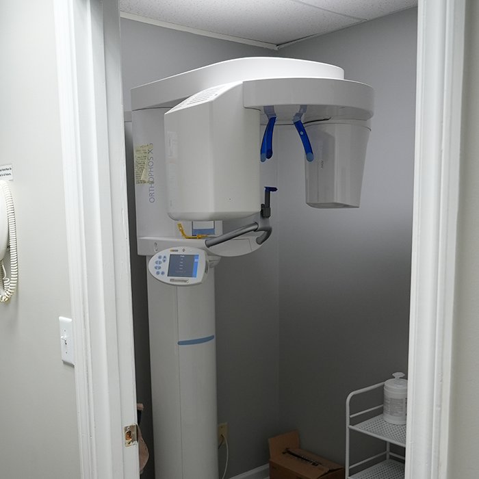 Large dental scanner standing against a wall