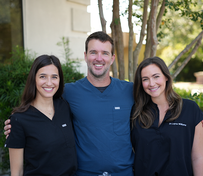 Three dentists at Carolina Complete Dental smiling outdoors