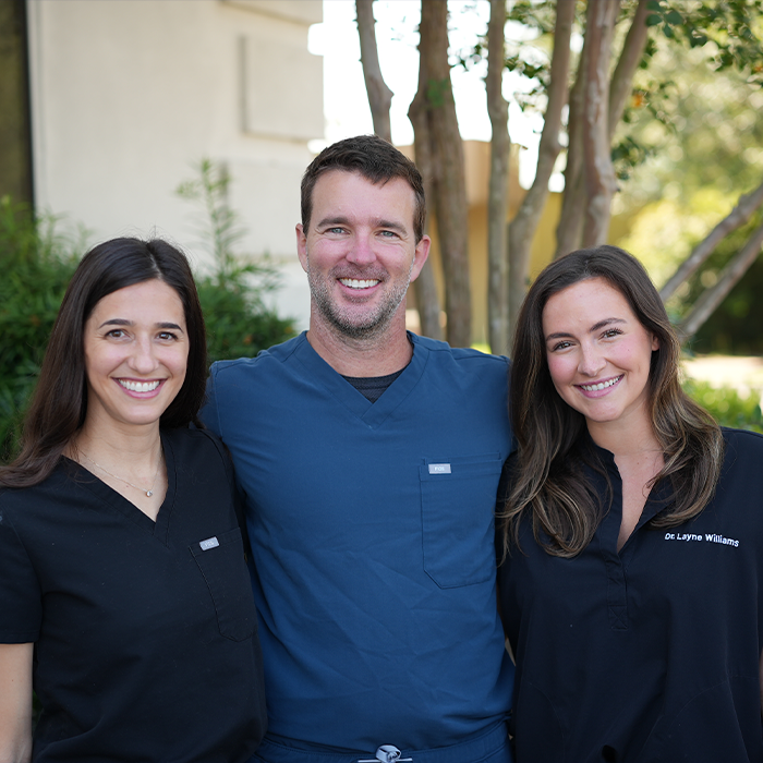 Three smiling Goose Creek dentists standing in front of Carolina Complete Dental