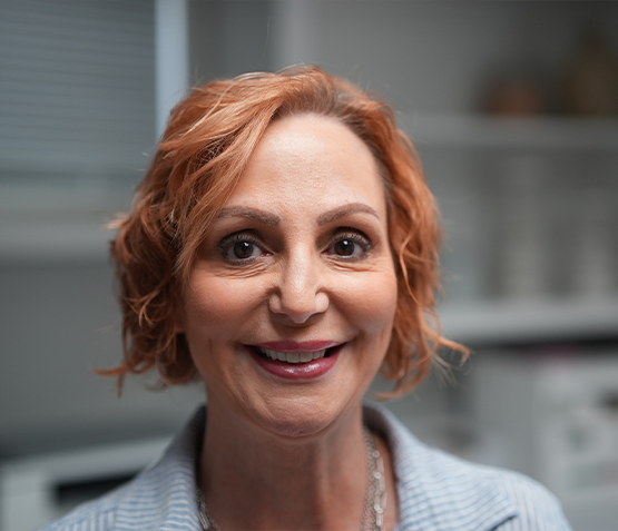 Smiling woman with short wavy orange hair