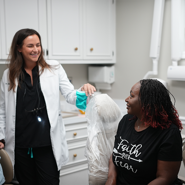 Dentist smiling at a woman in the dental chair
