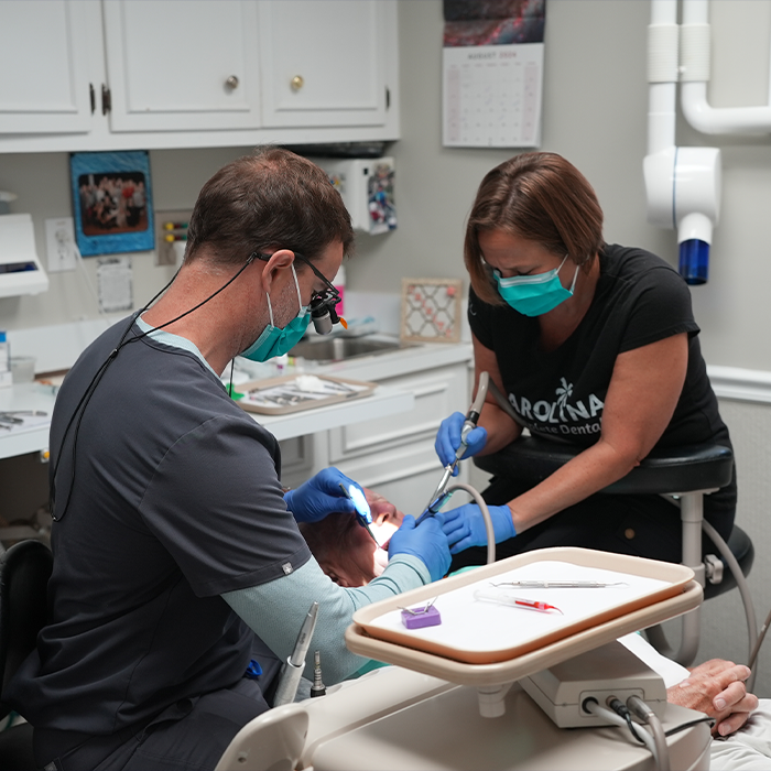 Goose Creek family dentist and assistant performing a dental procedure on a patient
