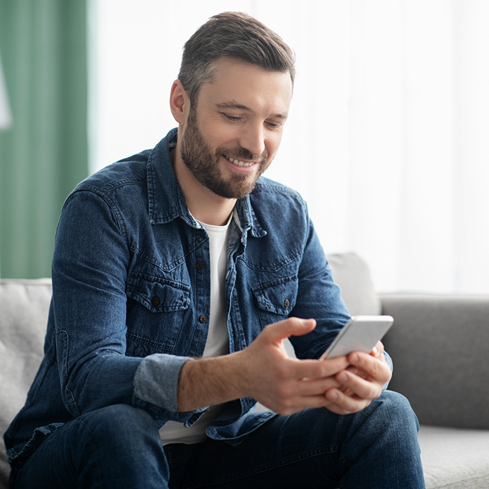 Man smiling while looking at his phone