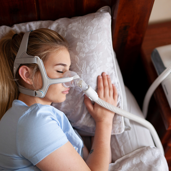 Woman sleeping on her side with a CPAP mask