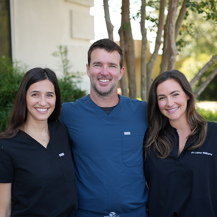 Three Goose Creek dentists smiling in front of Carolina Complete Dental
